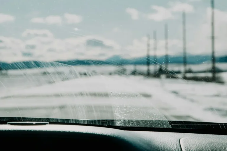 Snowy road seen through a streaky, frosted windshield